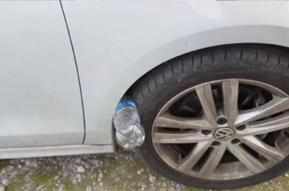 Bouteille en plastique placée contre un pneu de voiture