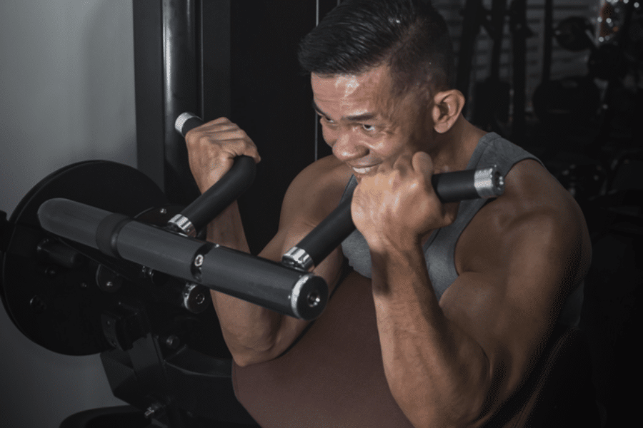 Homme utilisant une machine de musculation pour les bras