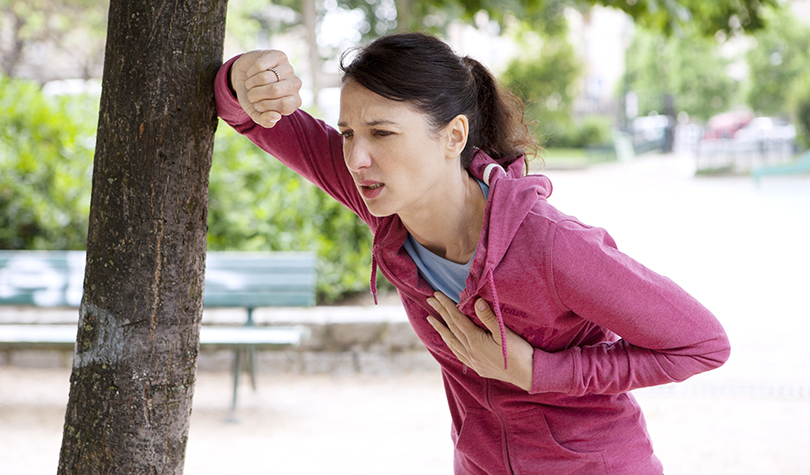 Femme essoufflée, main sur le genou après un effort
