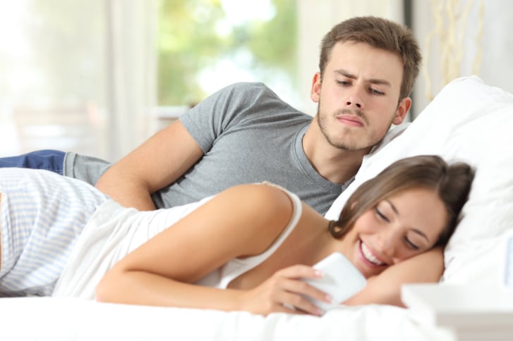 Homme regardant son téléphone avec suspicion