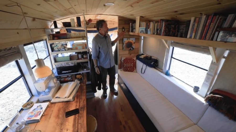 Intérieur chaleureux d'un bus aménagé avec bibliothèque intégrée
