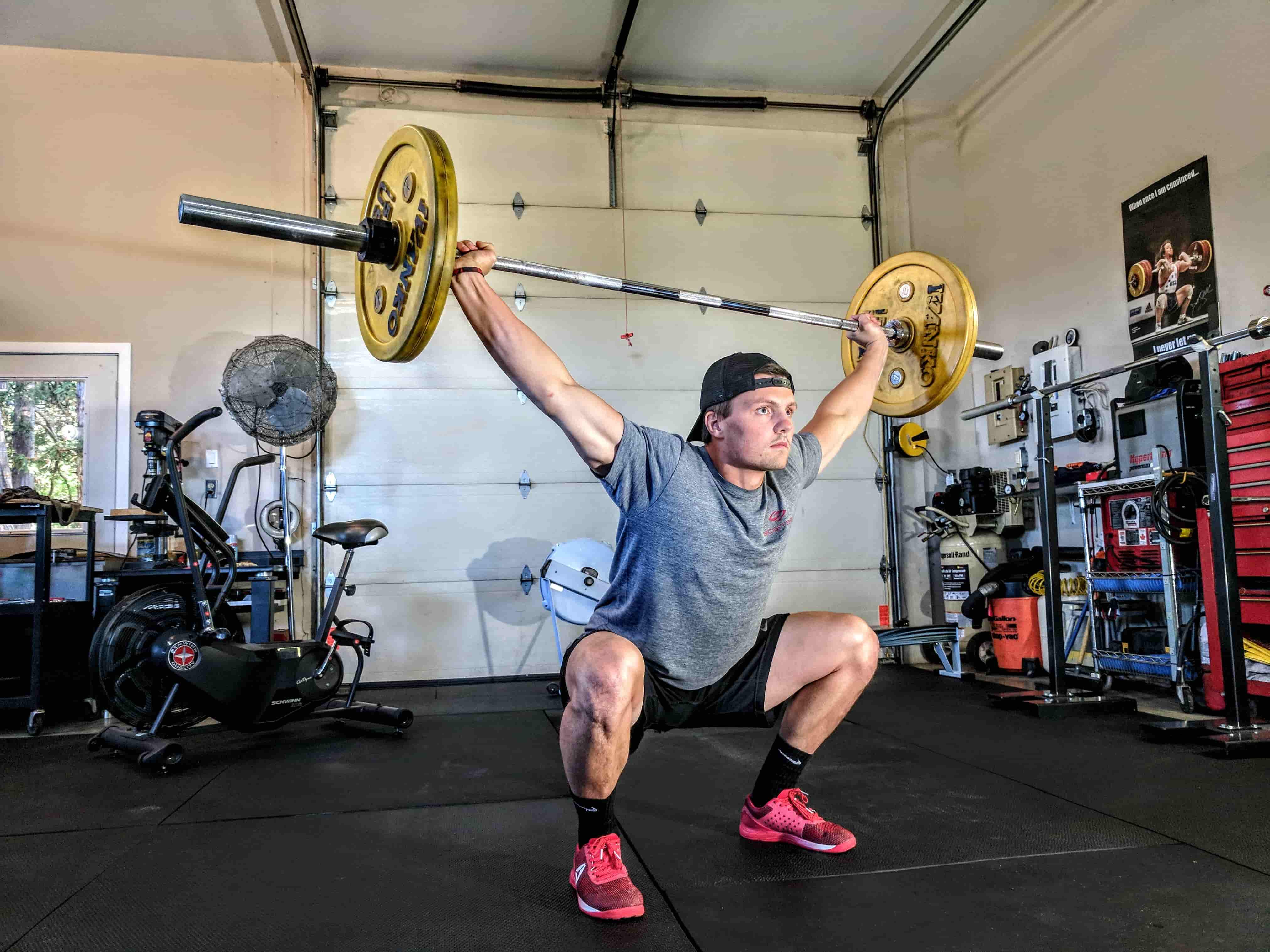 Homme effectuant un squat lourd en salle