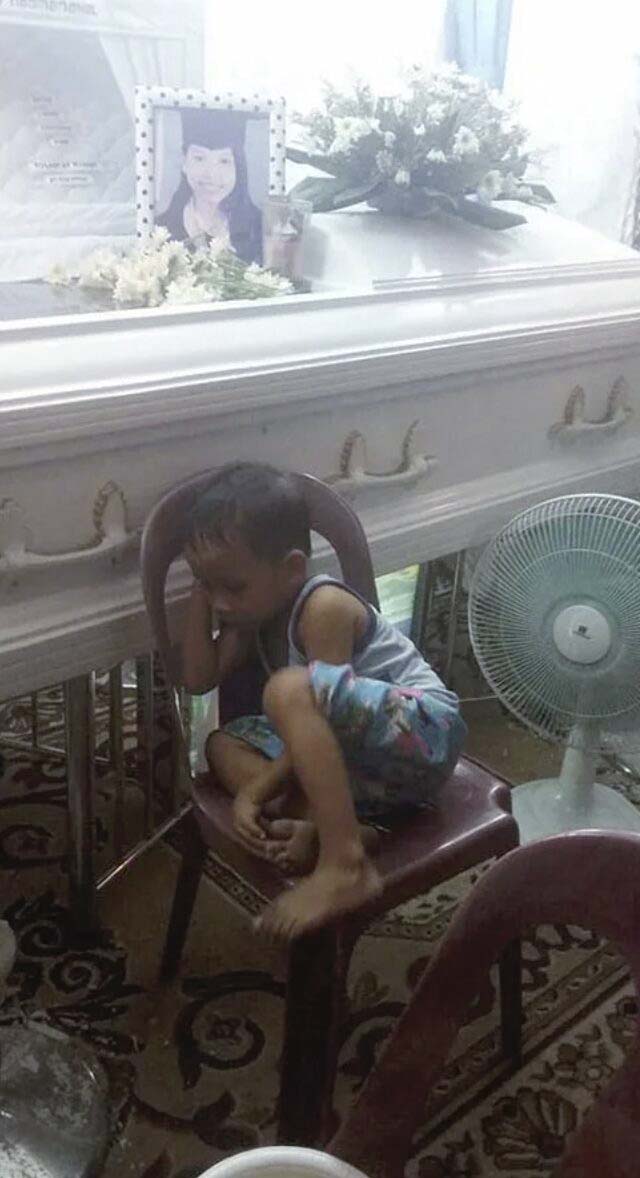 Un enfant enlace le cercueil de sa mère