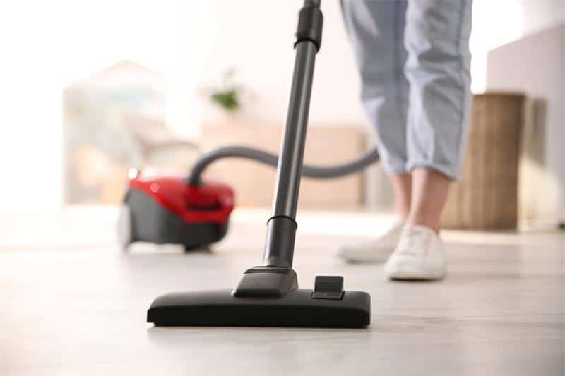 Personne utilisant un aspirateur traîneau