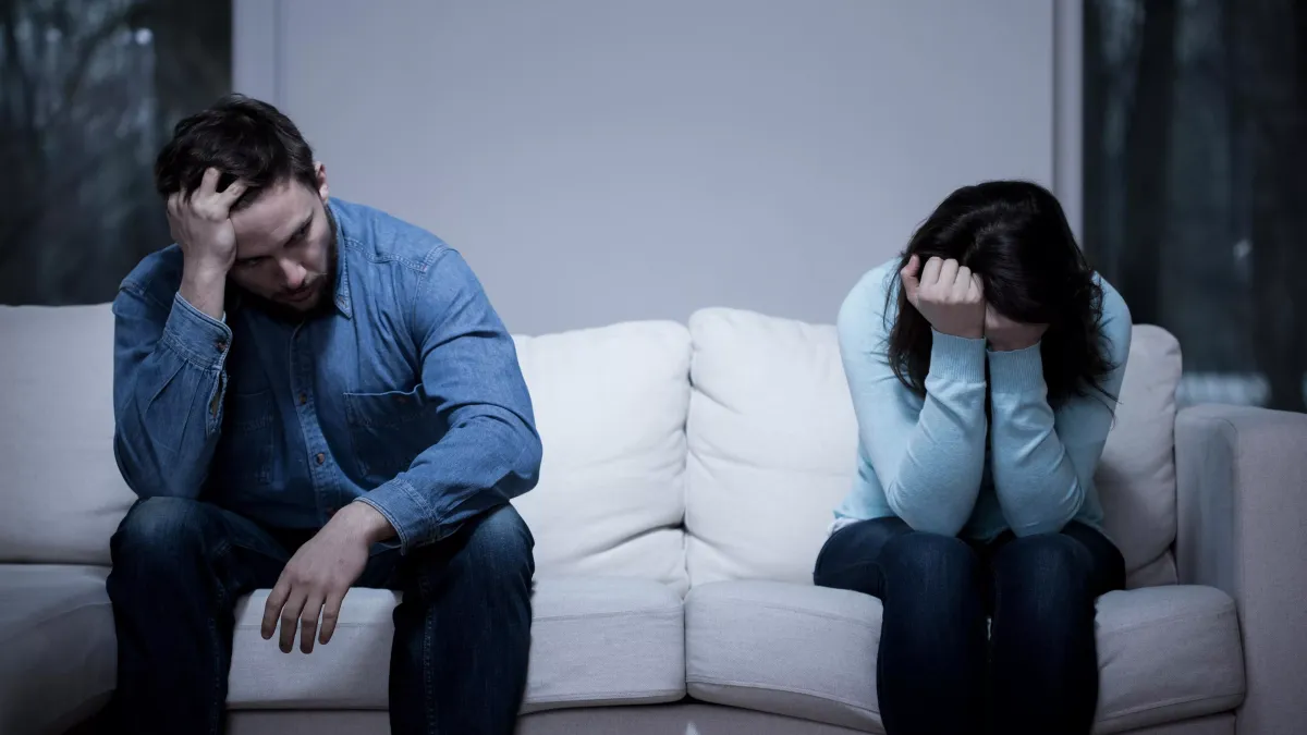 Femme seule sur un canapé contemplant son alliance